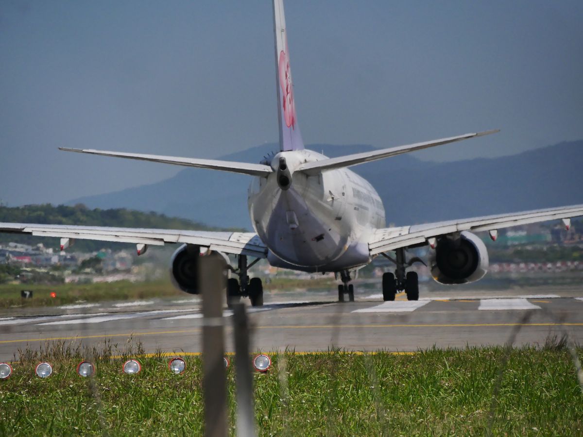 Airliner on its landing roll along the runway seen from behind
