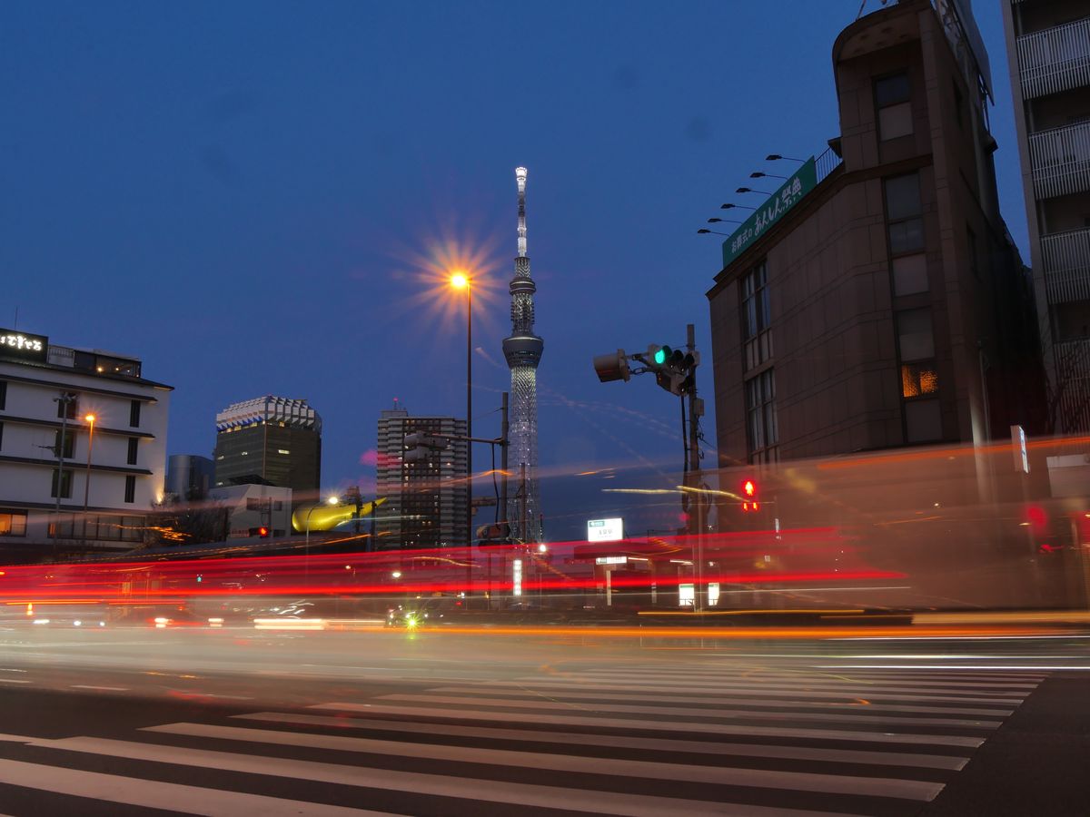 Tokyo Skytree at blue hour with red car light trails across the intersection